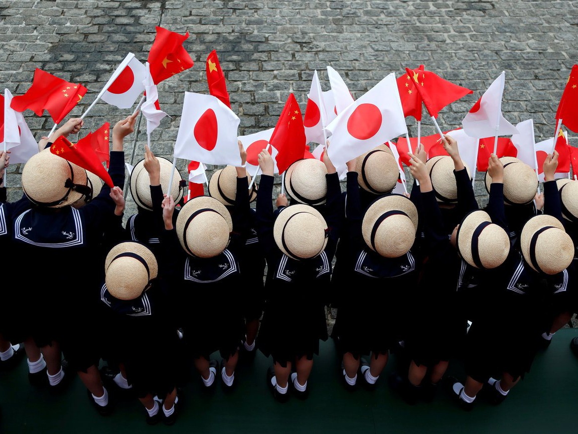 Preschoolers holding Chinese and Japanese flags